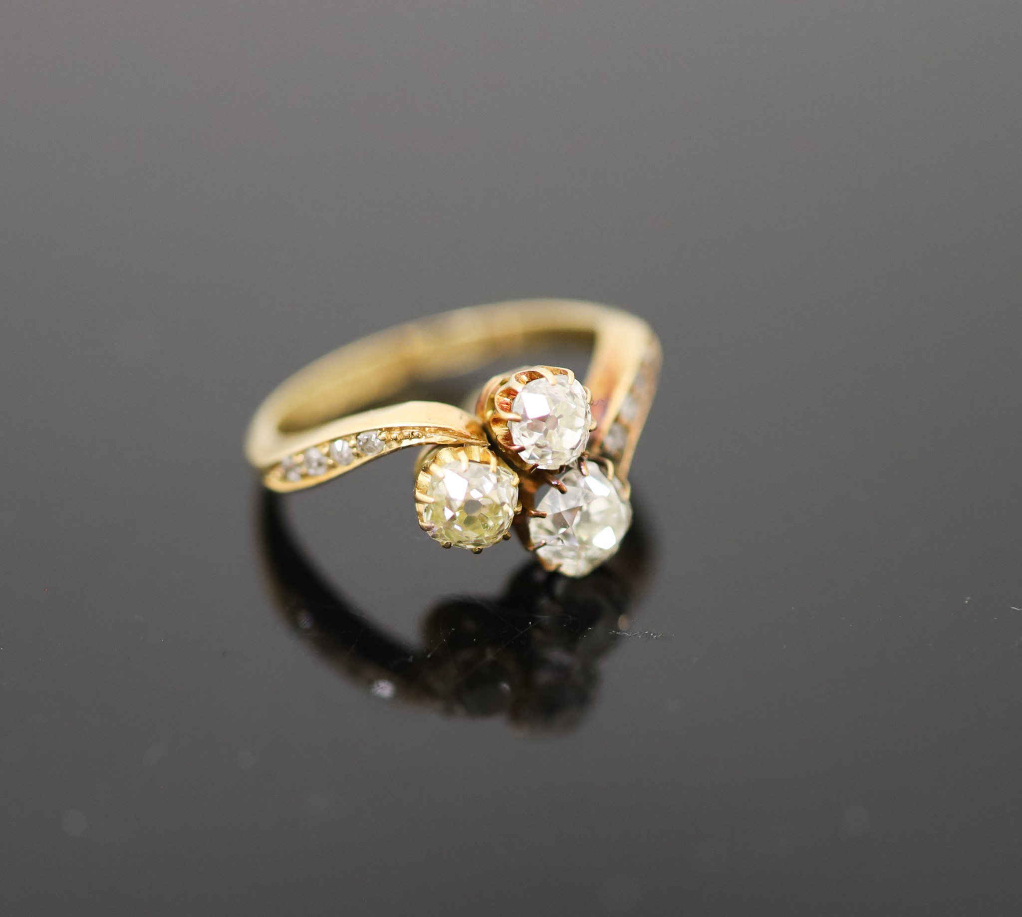 An Edwardian 18ct gold and three stone set clover shaped cluster ring
